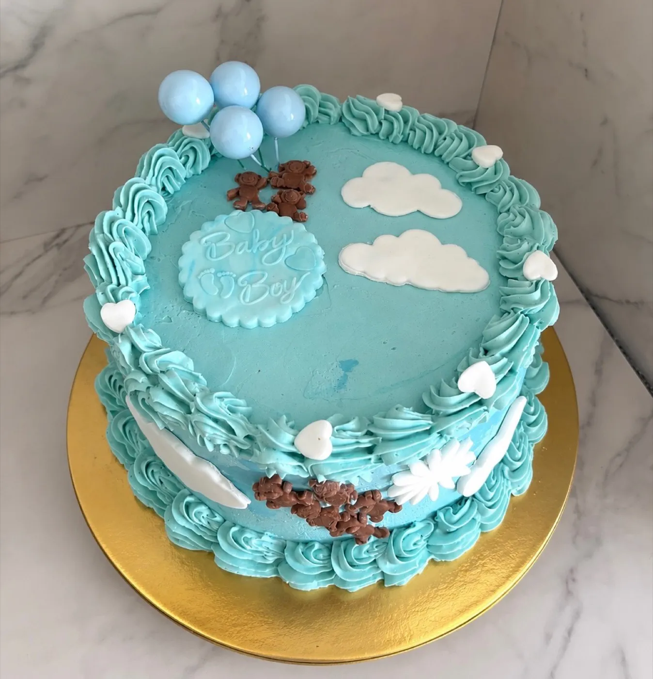 Babyshower-kage i blå smørcreme med fondantskyer, bamser og balloner