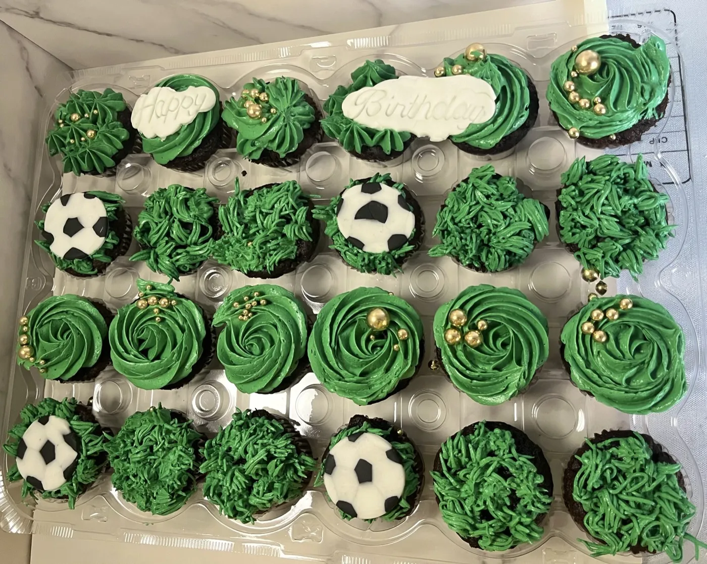 Fodboldtema-cupcakes med grøn græssprøjtning og fondantfodbolde