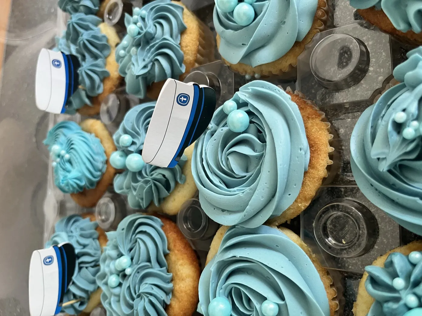 Studenter-cupcakes i blå smørcreme med studenterhue-toppere
